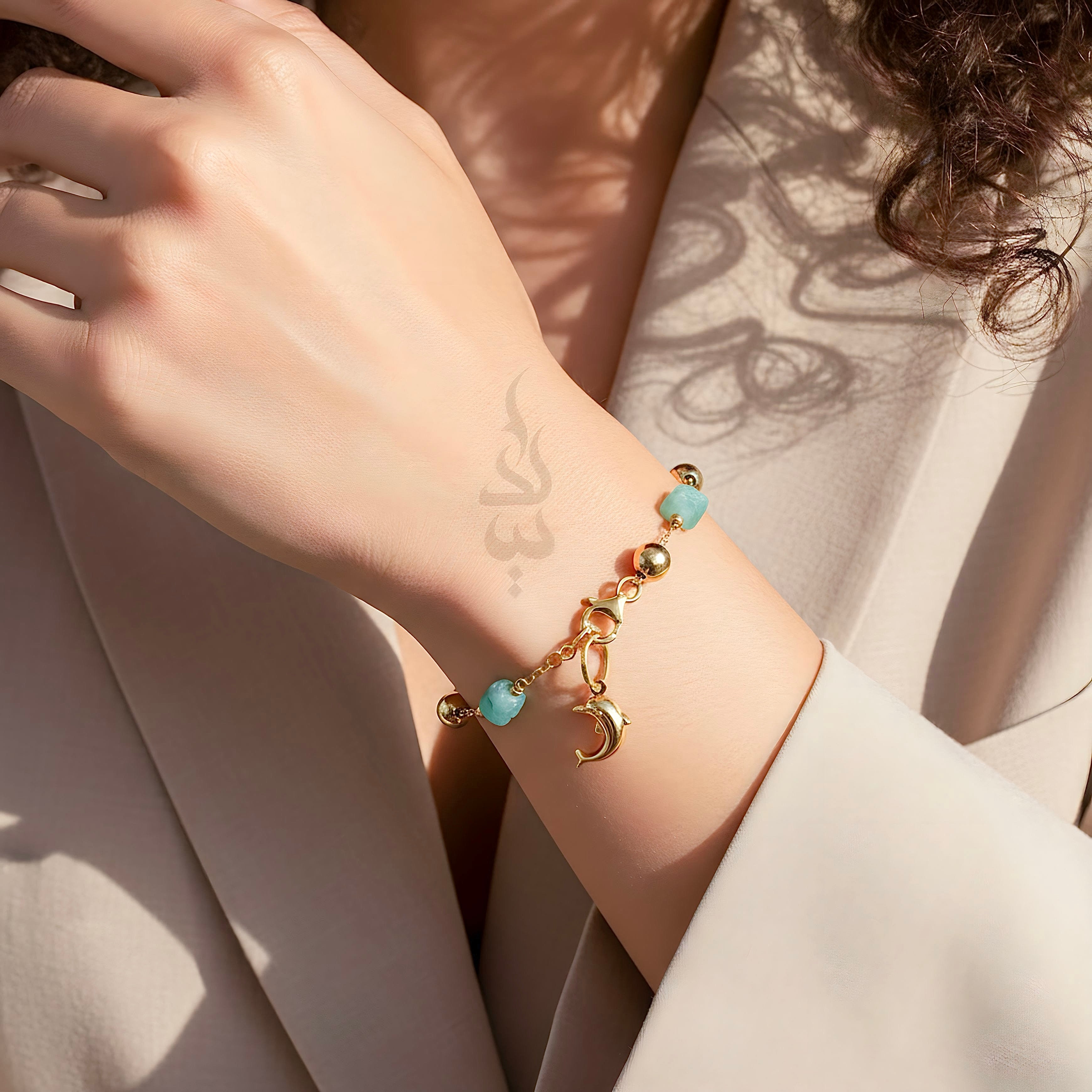 18K gold bracelet with a dolphin charm crafted with ammonite stone