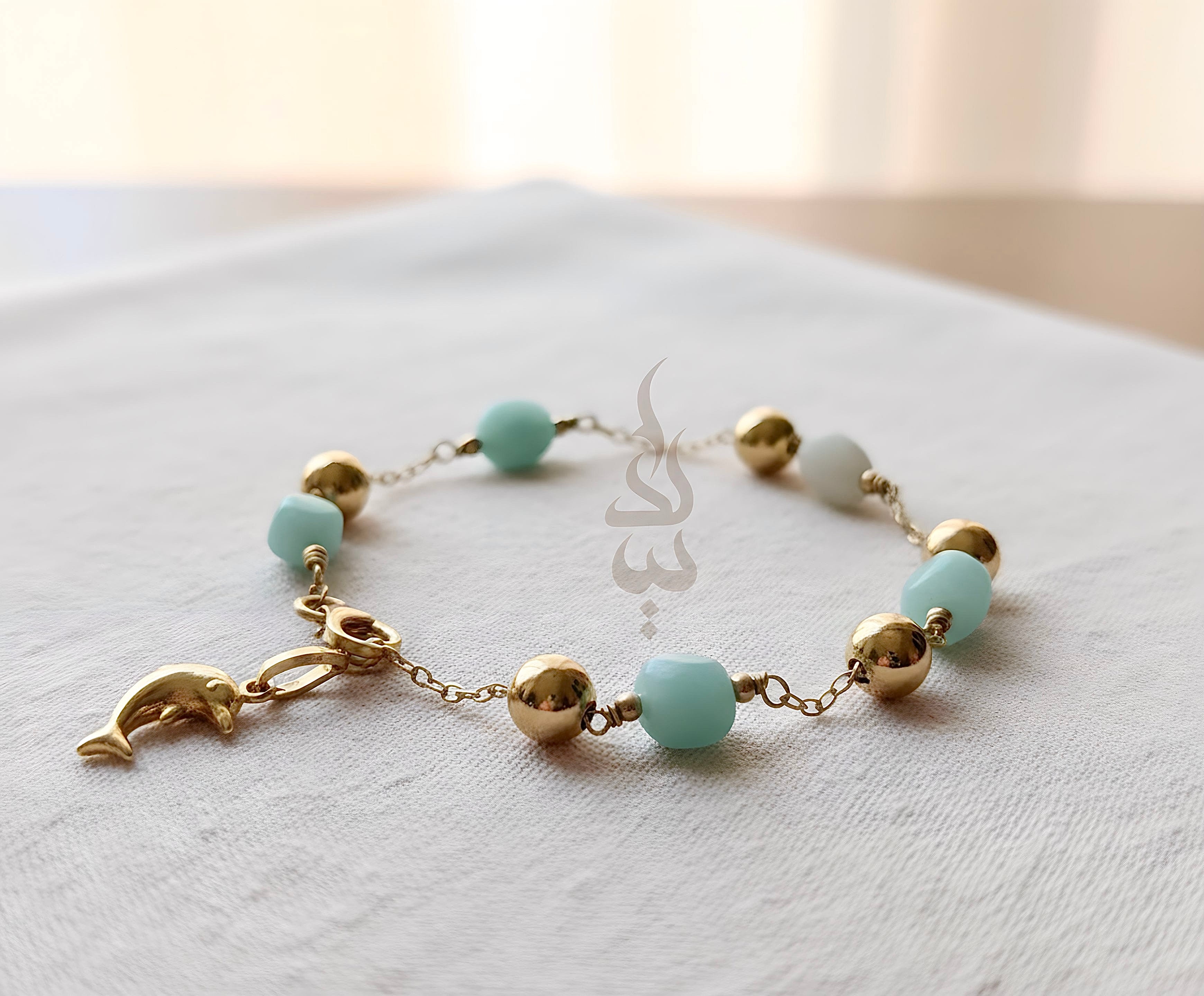 18K gold bracelet with a dolphin charm crafted with ammonite stone