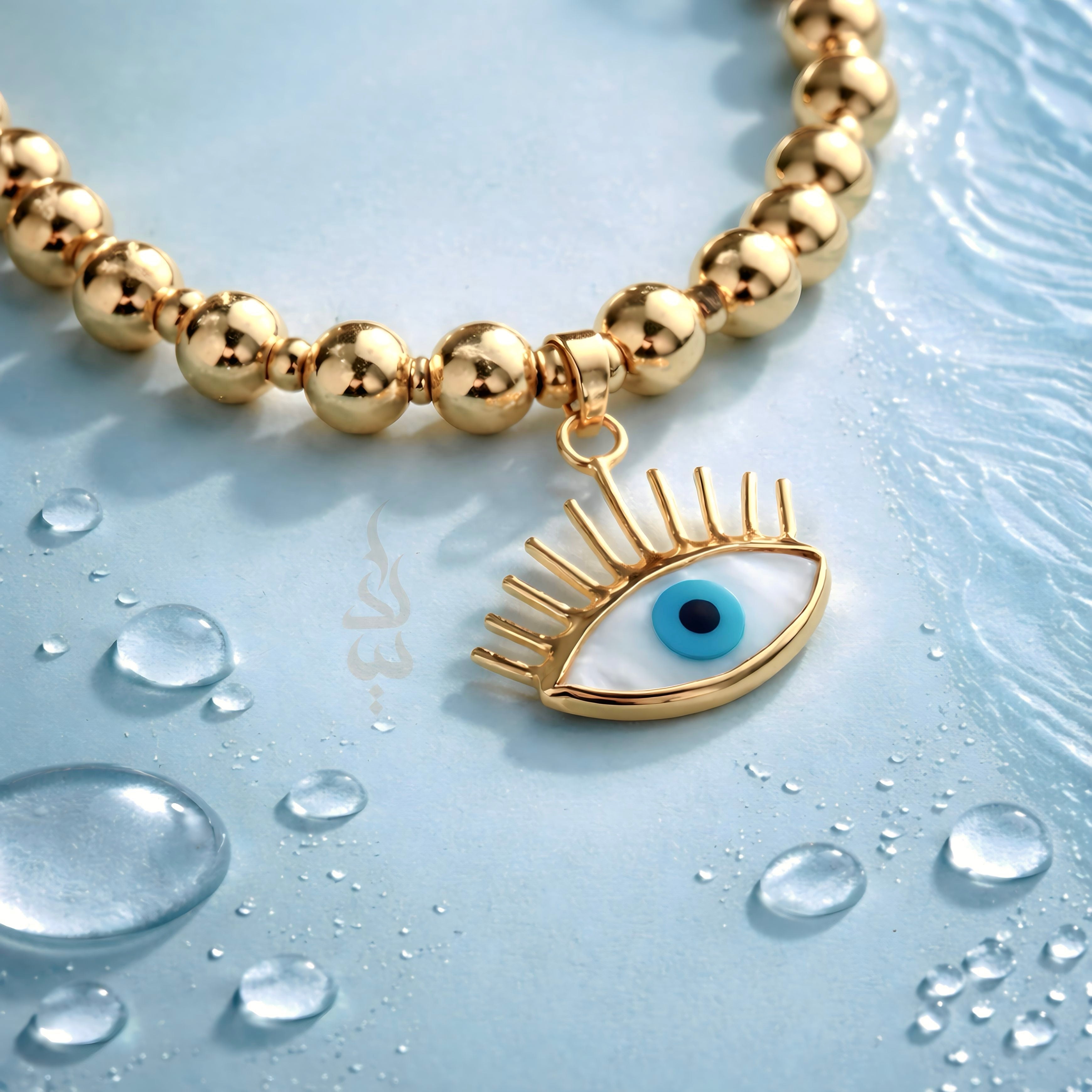 18K gold bracelet featuring polished gold beads with eye charm