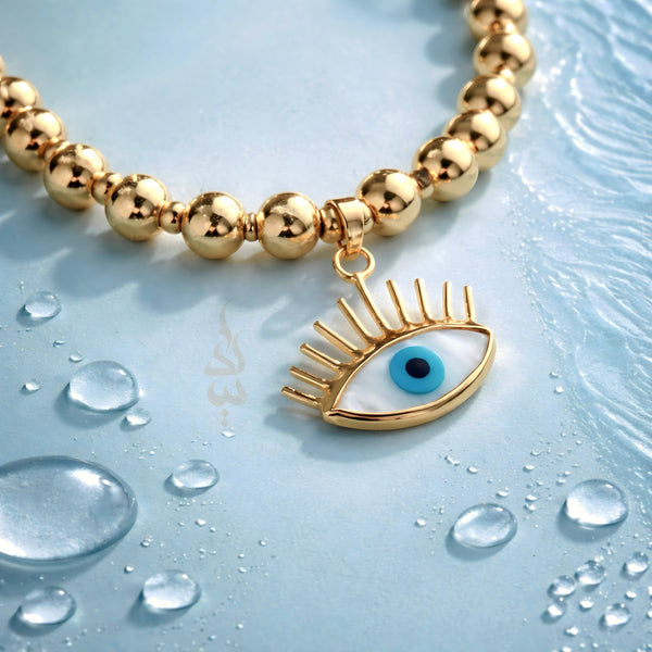 18K gold bracelet featuring polished gold beads with eye charm