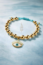 18K gold bracelet featuring polished gold beads with eye charm