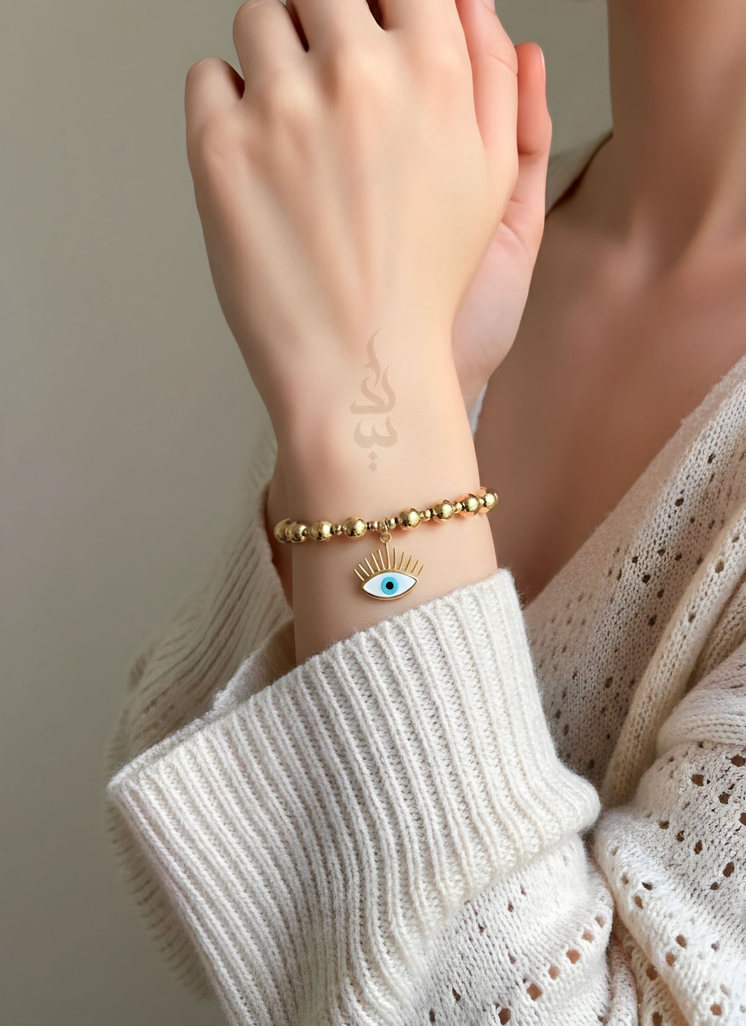 18K gold bracelet featuring polished gold beads with eye charm