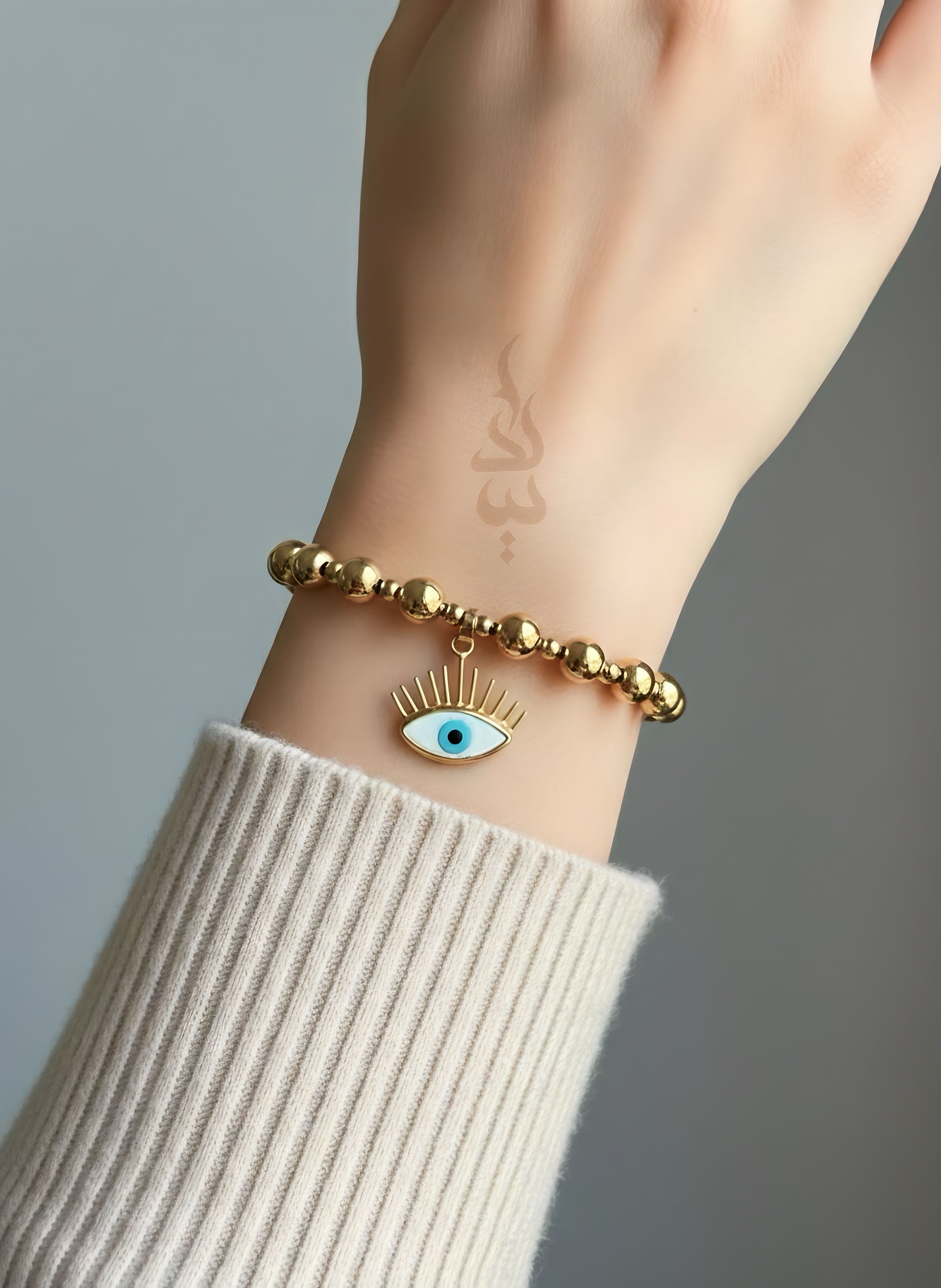 18K gold bracelet featuring polished gold beads with eye charm